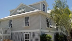 bahama hurricane shutters on tan house