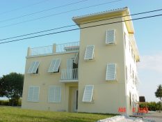 Eurex Bahama Shutters install on yellow house