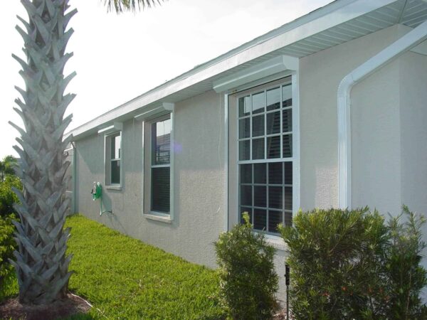 new, white automatic shutters installed on a house in Fort Myers FL