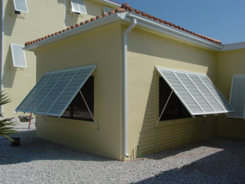 Image of wide Bahama shutters over windows of a residential home