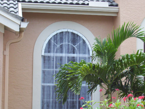 Image of clear, polycarbonate storm panels installed over a window of a residential home