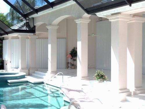 Pool home with accordion shutters covering doors