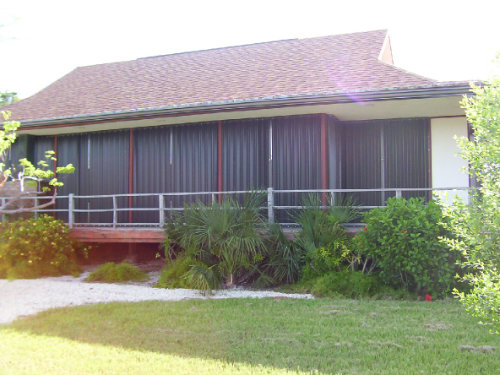 Beach house with bronze accordion shutters