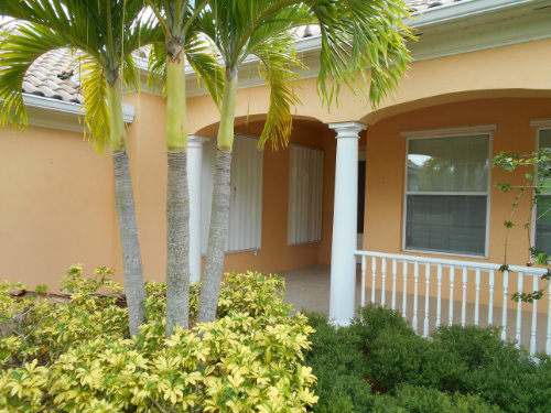 White accordion shutters on a yellow house