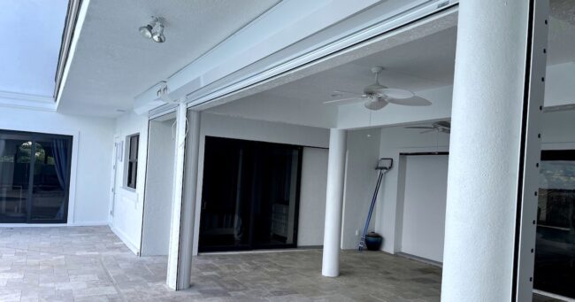 white electric roll down shutters on white home cape coral FL