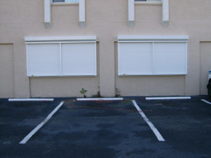 White roll down aluminum shutters installed on a commercial building in Fort Myers, FL