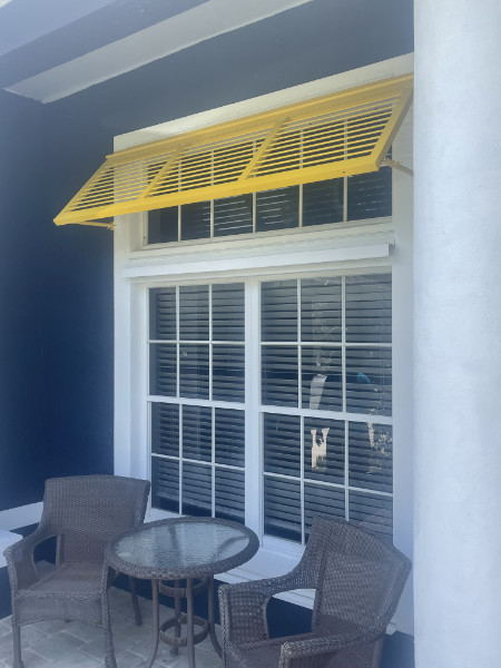 Yellow Deco Bahama Shutters on blue home Fort Myers FL