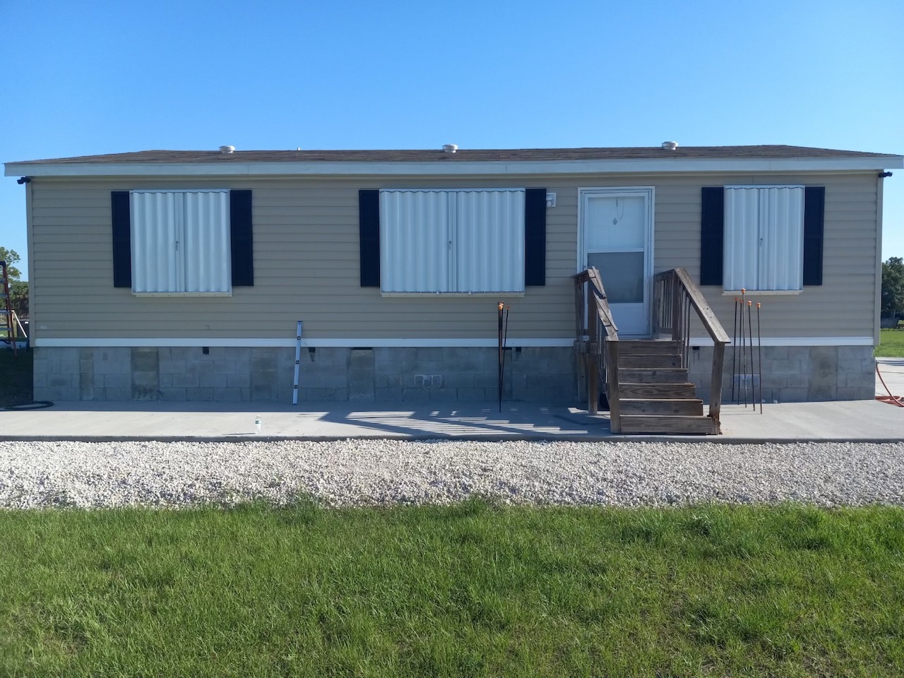 tan house with white eurex shutters ptx accordion shutters in lehigh acres fl