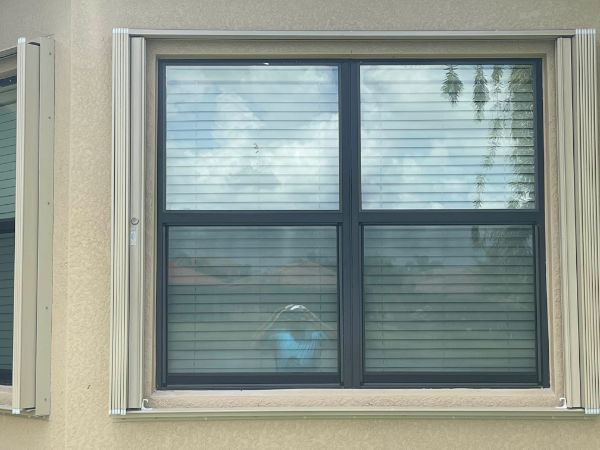 Open accordion shutters on a black window