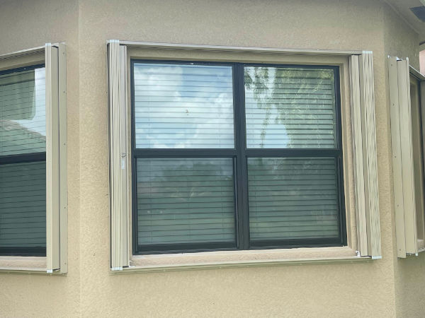 Open accordion shutters on black windows