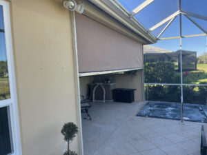 Aramid storm screens in partially closed position on a tan home in Fort Myers