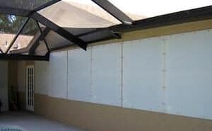 Hurricane fabric panels covering windows of a patio