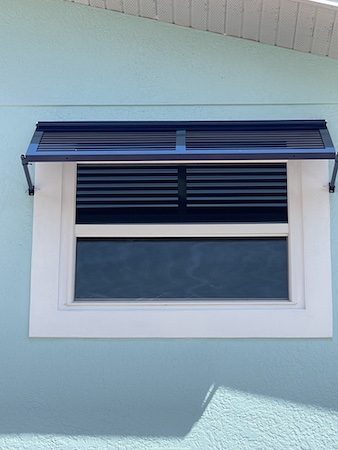 Deco Bahama Shutters on a white, single window of a beach home in Fort Myers Beach FL