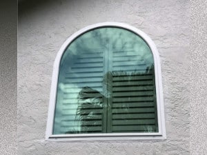 Tinted impact window shown on a tan home in Bonita Springs.