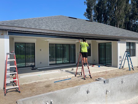Hurricane shutters being professionally installed on a home.