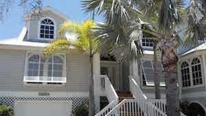 Hurricane shutters on a tan home in coastal Southwest Florida