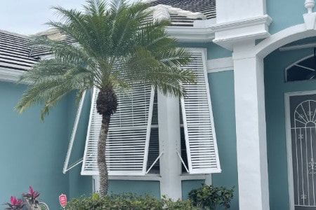 White aluminum Bahama Shutters provide shade and privacy to a home in Englewood Florida.