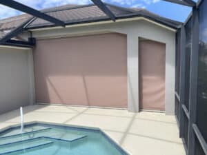 Light brown hurricane screens covering patio near a pool