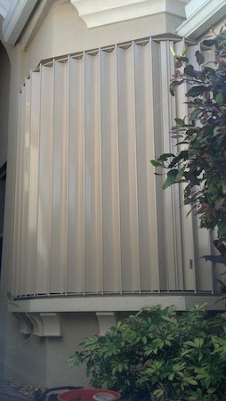 Beige accordion shutters on a tan home in Southwest Florida