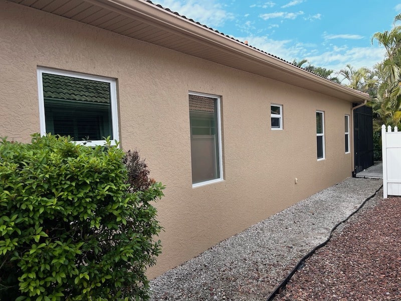 White, vinyl impact windows installed on the side of a home in Naples Florida