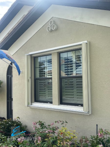 Ivory accordion shutters shown in the open position on a home in Fort Myers FL.