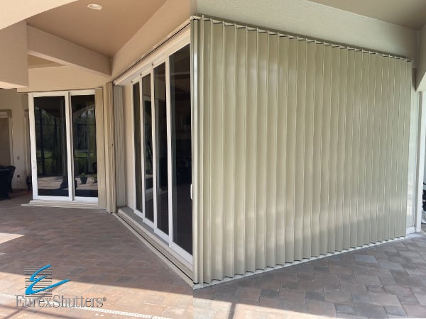 Beige accordion shutters on a condo in Estero FL