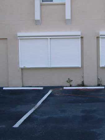 Commercial roll down shutters shown closed over an office building window