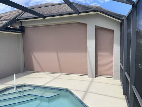 A view from outside the house of hurricane screens lowered. The housing boxes are hidden and the set-up is clean looking.