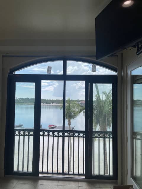 A bronze impact sliding glass door with arch windows installed above
