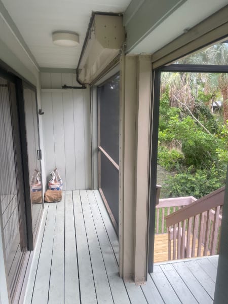 Beige roll down shutters shown in the open position on the back porch of a home in Sanibel Florida.