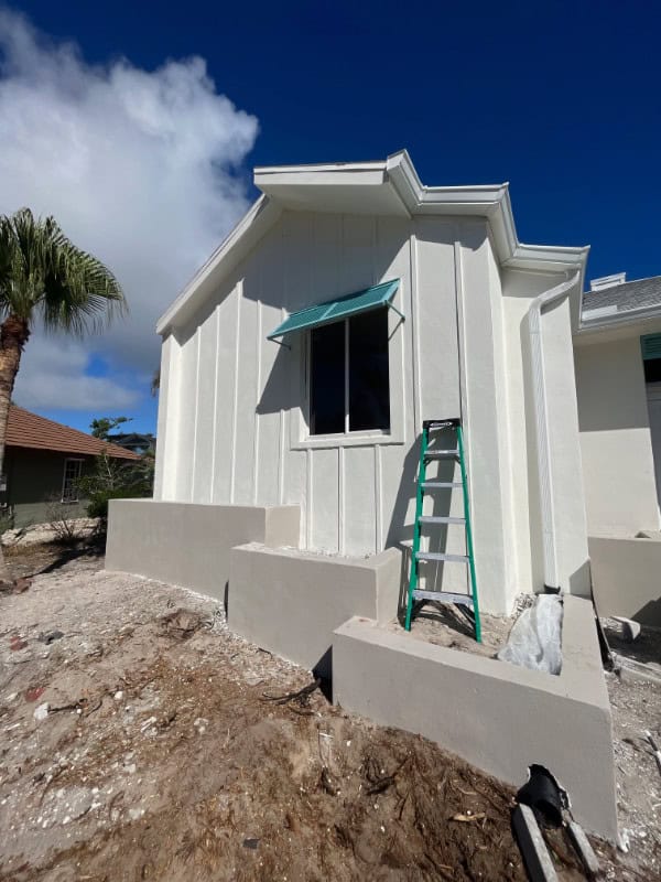 A blue deco half-bahama shutter installe over a window of a home.
