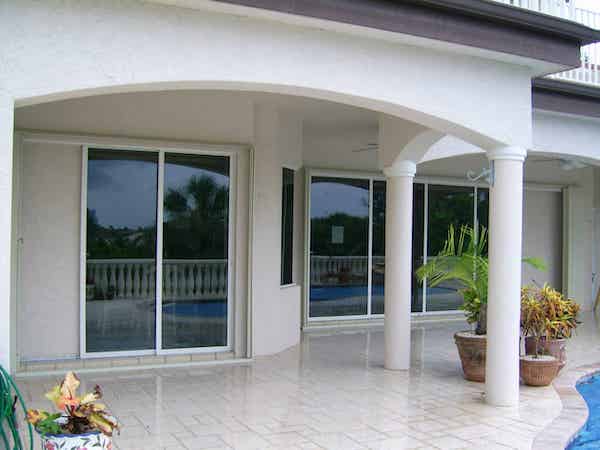 Ivory accordions shown open on a light colored home's patio area.
