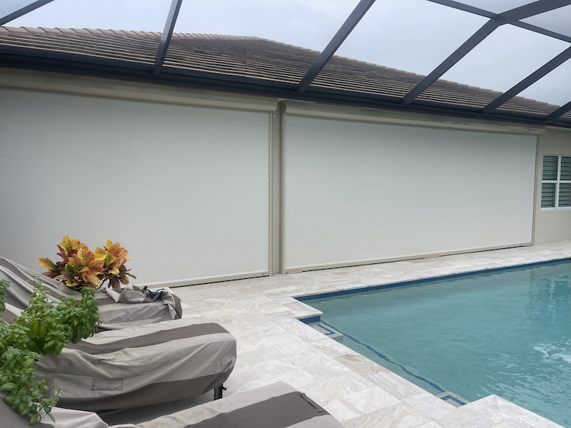 Two, white, hurricane screens installed side-by-side on the exterior of a lanai on a pool home in Bonita Springs