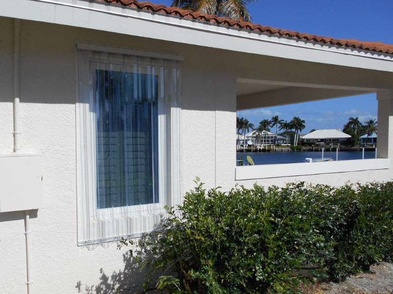 Clear corrugated storm panels installed on a window opening