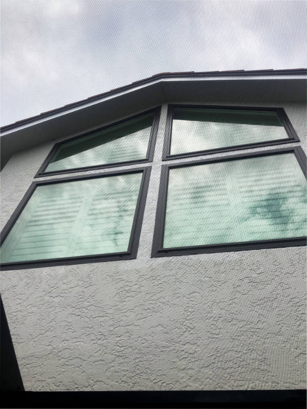 Bronze aluminum frame windows on a stucco house