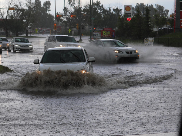 Cars driving through flooded streets