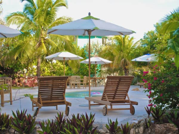 White patio shade umbrella near a pool.