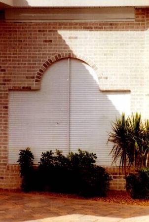 Roll down security shutters installed on a window of a commercial building in Fort Myers Florida