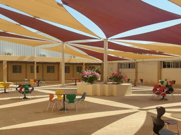 Red and yellow shade sails providing shade for a large patio.