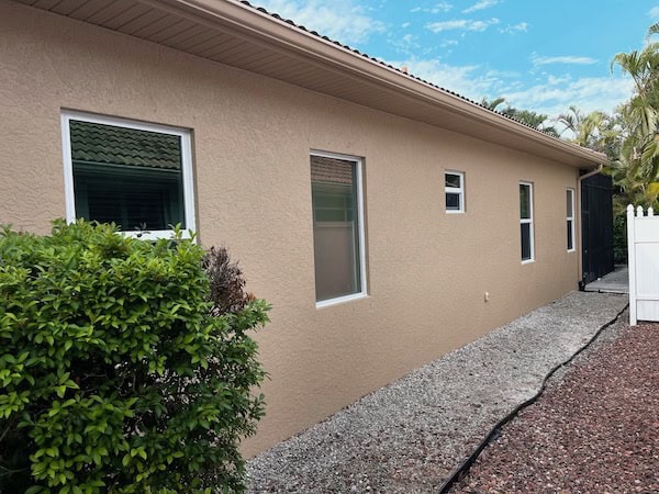 White vinyl impact-rated hurricane windows installed on a beige home in Fort Myers Florida.