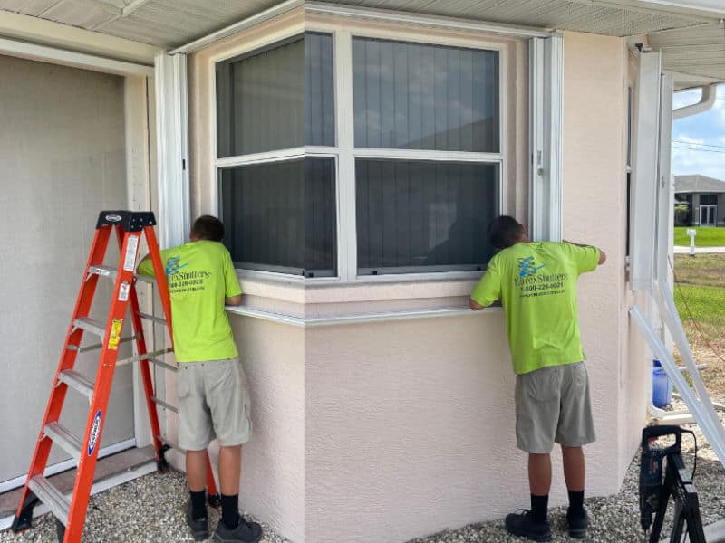 Eurex Shutters technician adjusting white accordion shutters