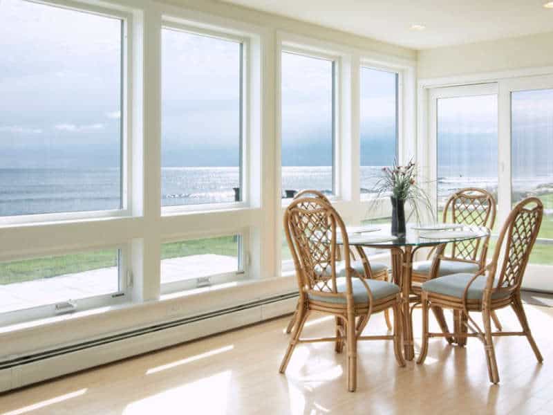 Awning windows and picture windows shown in the kitchen of a home looking out to the water.