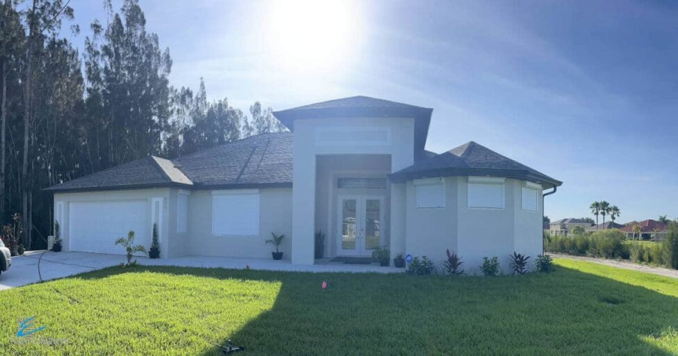 White roller shutters installed on the windows of a tan home in Lehigh Acres Florida