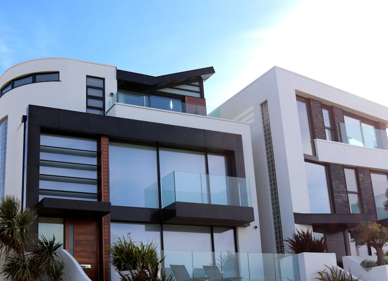 Modern home design with large windows, large glass, wood, and concrete.