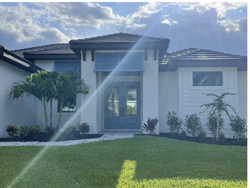 Coastal contemporary home style in Cape Coral Florida with blue door and blue Deco-Bahama shutters.