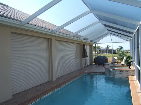 White roll-downs on a home's lanai near pool.