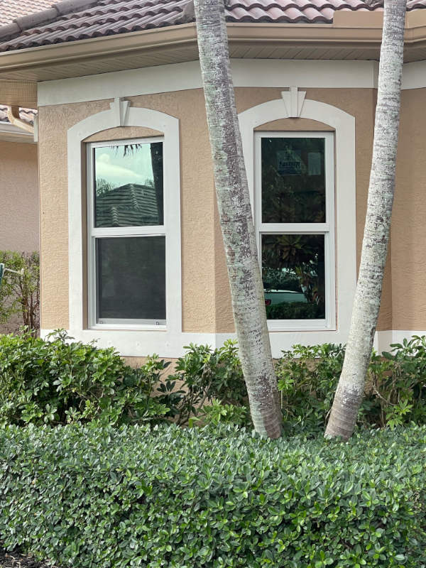 Impact windows on a tan, Mediterranean home with tile roof.